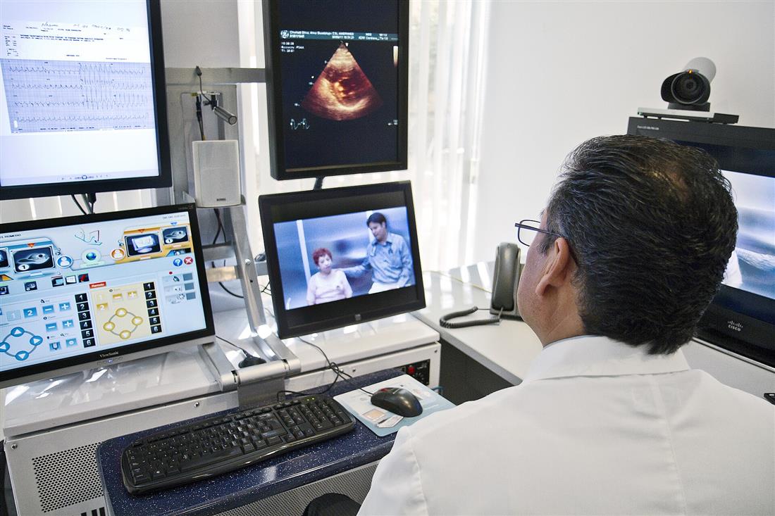 Médico frente a varias pantallas durante una consulta a distancia